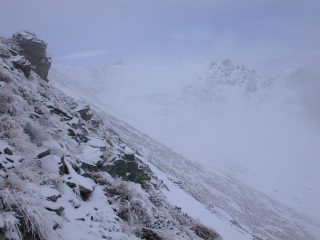 Sulla sinistra il pendio pericoloso sotto la cima (ora privo di neve). Al centro della foto il colle.