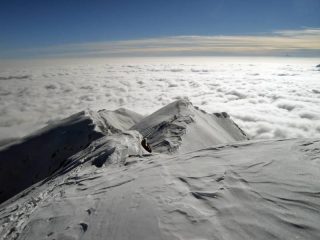 Dalla cima, sguardo verso la punta Cavalcurt e la pianura immersa nella nebbia