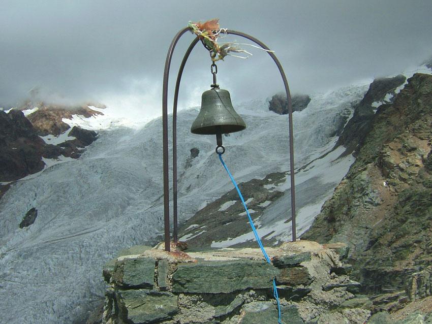 la campana di vetta con lo sfondo del ghiacciaio sotto il Castore