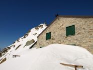 Il Rifugio Mombarone coperto di neve e la vetta dietro