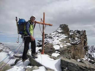 Croce dell'anticima escursionistica e dietro i torrioni che portano alla cima