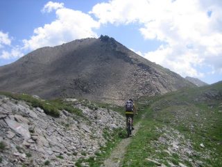 sulla sinistra il sentiero che risale il versante roccioso del Ruetas