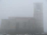 La chiesa in vetta al Monte Tobbio avvolta dalla nebbia