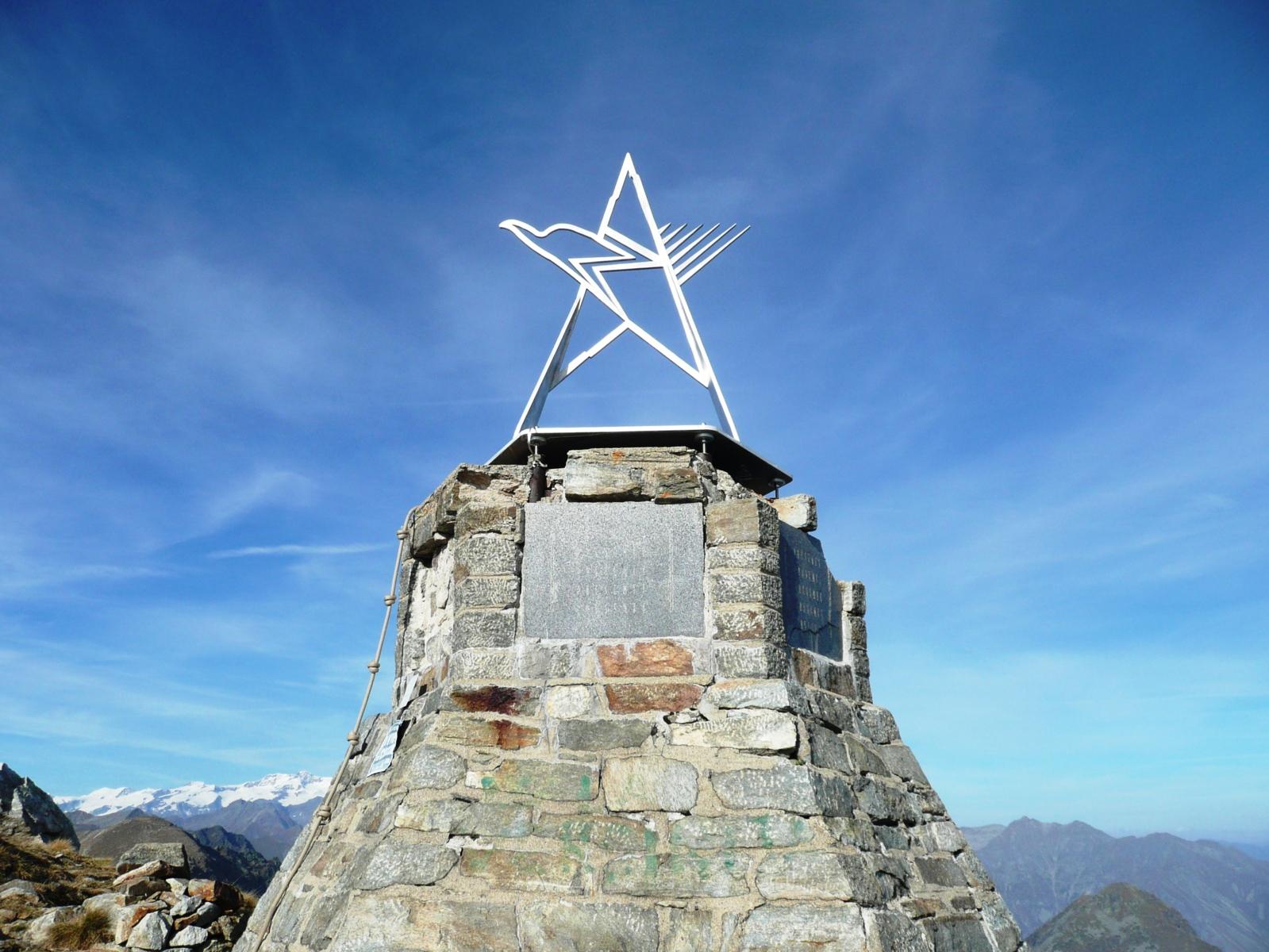 sulla cima la scultura con il logo stilizzato del Cai (stella, aquila e Monviso)