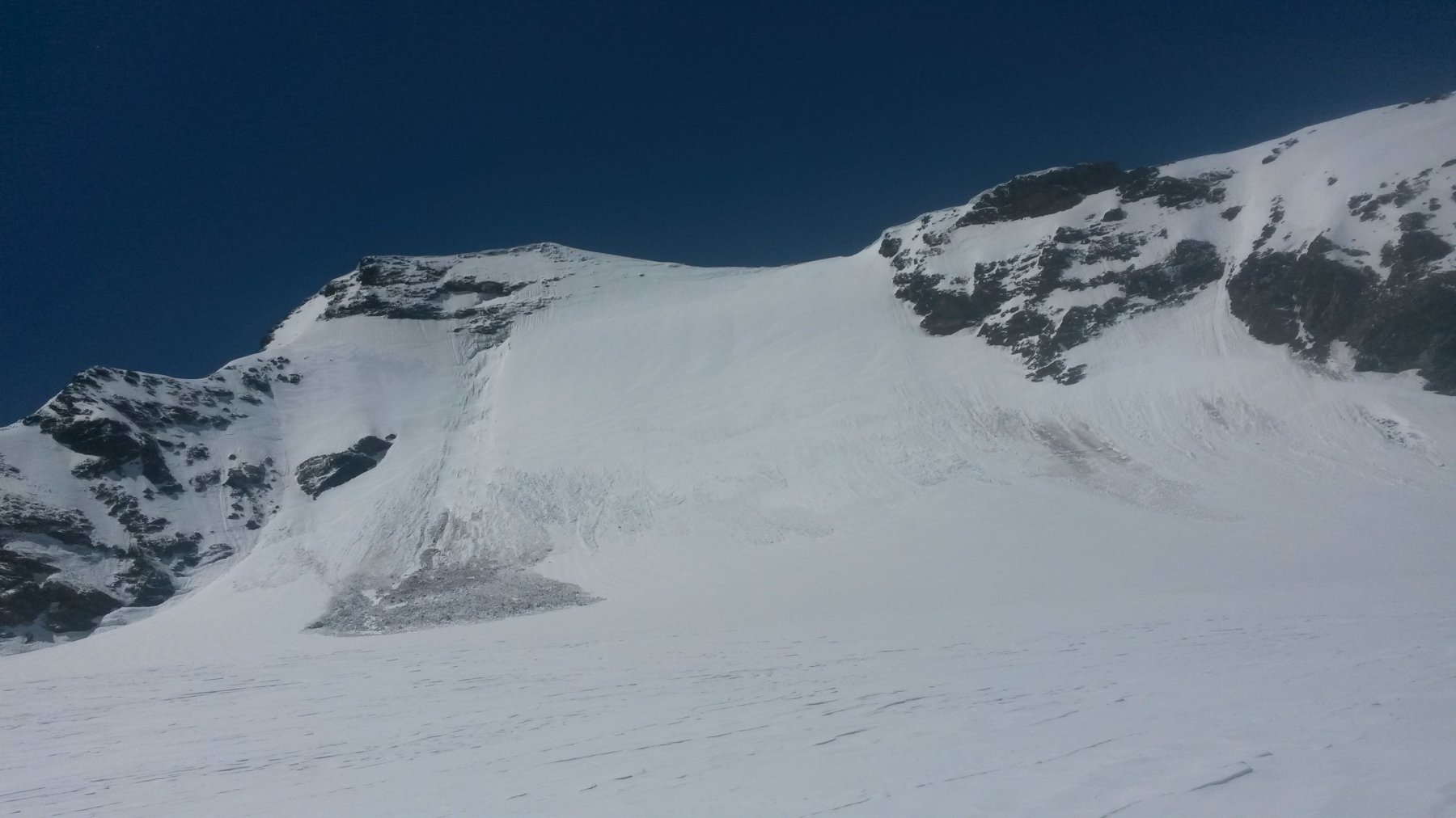 Scollinato il Col d'Oin, si attraversa il ghiacciaio proprio davanti alla Nord della Grande Aiguille Rousse