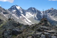 In vetta. Sullo sfondo Paramont, Testa di Paramont e Mt. Monchette; dietro la palina il Passo Alto sull’AV2.
