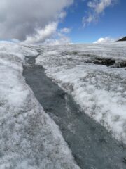 Nei pressi del colle della Resta: uno scrosciante torrentello da scioglimento sul ghiacciaio (foto E. Lana).