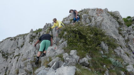 un gruppo di escursionisti impegnati sulle roccette sommitali, appena sotto la cima
