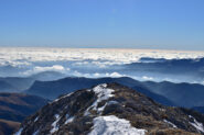 Dalla cima sguardo verso il mare di nuvole e la Corsica in lontananza