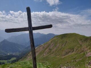La croce della cima Ol Poiat, in lontananza la Cima Fontane