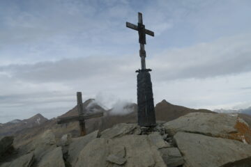la Punta Chaligne, sulla destra della croce di ferro la Tsa di Chaligne a sinistra nella nebbia la Punta d'Arsy ed il Fallere