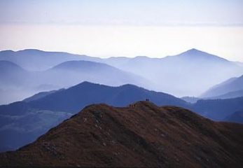 Dalla Cima di Grem verso la pianura: in primo piano l'affilata cresta erbosa di discesa.