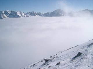 Pendio terminale con sfondo sullo spartiacque con la val Gesso sopra le nuvole