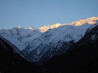 Primo sole con luna sul massiccio del Gran paradiso