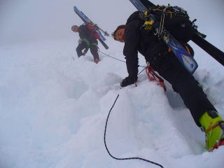 Paola e Renzo nella nebbia risalgono il pendio sotto il colle