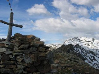 La croce di vetta e la Cima di Bonzè sullo sfondo