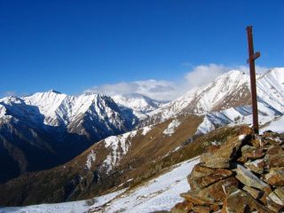 La croce di vetta e l'alta valle nella tormenta