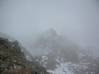 Nella nebbia il colletto ad ovest del Mont Ours, dove termina la Grande Gorge, cresta ovest e sommità del Mont Ours fotografati dal versante sud-est dell' Envers du Lac Gelé.