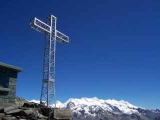 la croce di vetta e il rosa sullo sfondo