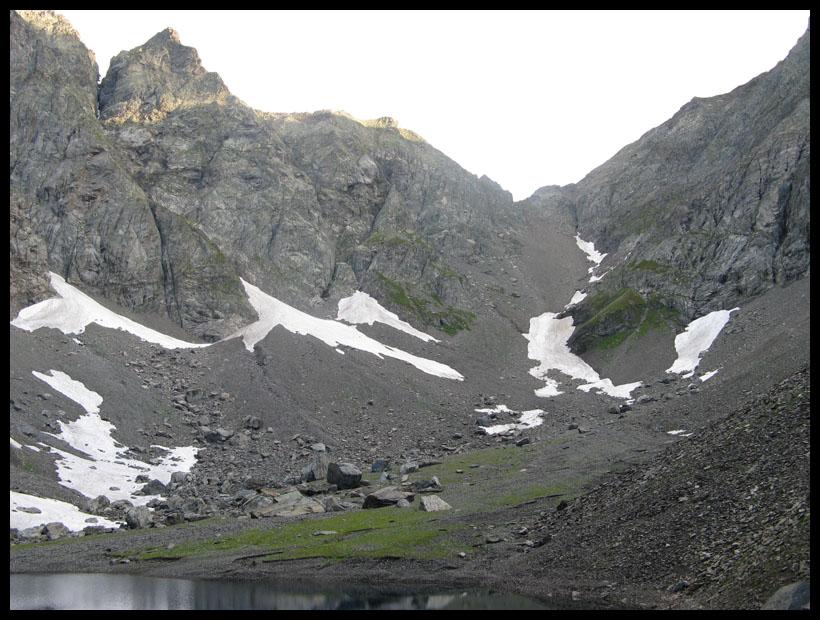 Il Pizzo Porola dal lago di Coca. La cresta di salita è illuminata dal sole.