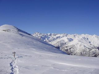 Linea di cresta tra la Cima dell’Uia di 2142 m. ed il M. Soglio 1971 m. dove un chiaro cartello indica a destra il percorso per quest’ultimo e a sinistra per la Cima dell’Uia e dell’Angiolino