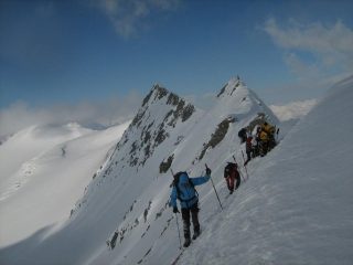 si calzano gli sci per raggiungere il deposito sotto la cresta sud