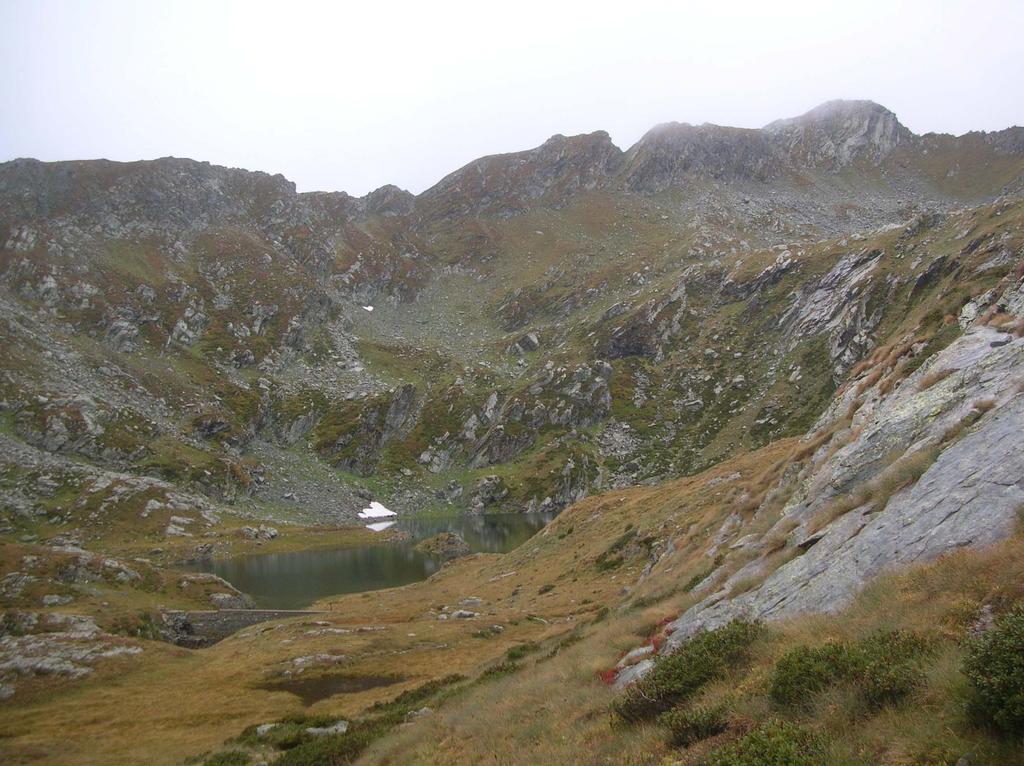 Il lago Chiletto. In alto a destra l' edificio sommitale del M.te Snatanel con, sulla sinistra, il canale erboso che consente di raggiungere la cima.
