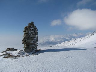Torretta in pietra del Bric Paglie con sfondo le montagne Canavesane