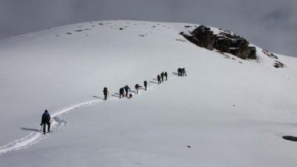 una lunga fila di ciaspolatori