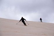 in discesa sull' ampio costone, con la neve colorata dalla terra riportata dal vento