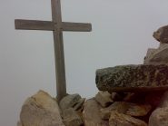 La croce di vetta, con dietro la nuvolaglia in arrivo.