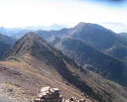 Salendo alla cima, a ritroso l'anticima. Sullo sfondo a destra il Monte Ruioch.