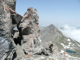 Passaggio sul primo torrione sotto il masso inclinato, sullo sfondo il Bric del Mezzogiorno o punta del Beth