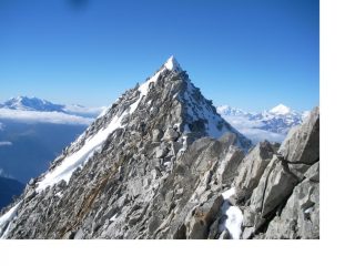 Ora e' il punto culminante a essere visto dalla croce.La bianca piramide del Weisshorn spicca al fondo a dx