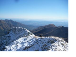Giovanni percorre l'ultimo tratto di cresta innevata alla vetta..