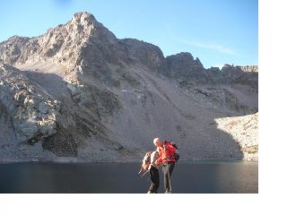 I soci Paolo e Rodolfo paiono galleggiare sulla superficie calma del Lago Portette sullo sfondo della Cima  che da li nome al Lago stesso.