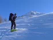 Appena fuori dai pini il vento si fa sentire e la neve ne risente, sullo sfondo il monte Banchetta