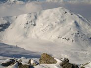 Dalla vetta, a Nord-Ovest si vede la Testa di Cervetto (2347 m), sopra i Laghi Luset, coperti di neve