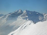In ombra i pendii orientali del Voghel visti dai pressi della cima del Monte Cresto (Vallone di Tourrison). Al sole si intuisce il vallone che, dai piedi della cresta est, scende nel vallone di Scheity