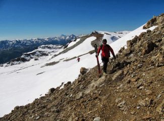 Sci in mano sotto la cima