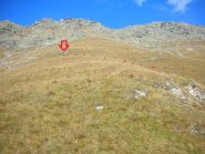 dal mini-pianoro sopra la cava, salire lungo la massima pendenza fino alla pietra allungata (freccia)