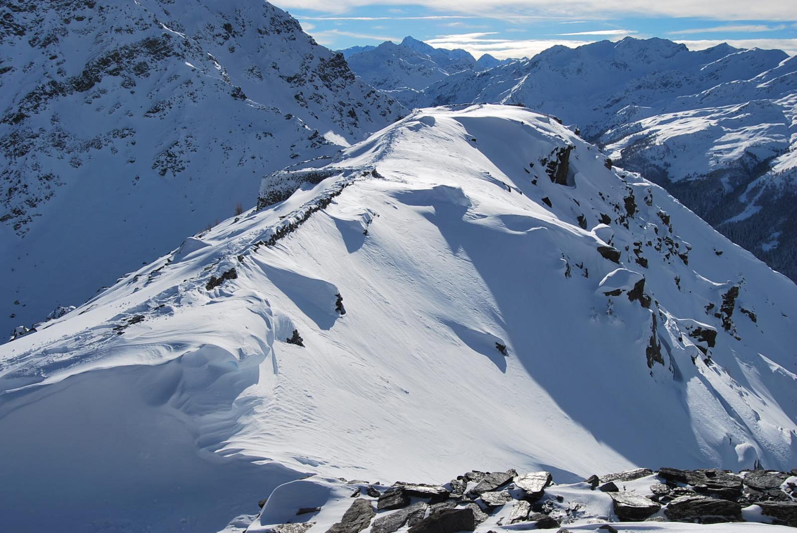 La cresta, splendidamente illuminata, che dalle fortezze scende alla Croce e poi al Colle.
