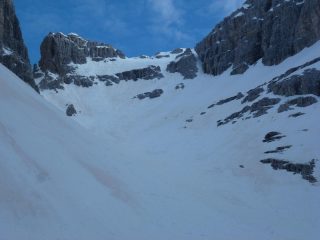 La Busa di Dentro e in fondo il ripido pendio con il canaloni e i piani superiori a dx che portano in vetta