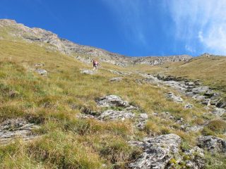 Risalendo il pendio erboso a lato del rio in secca