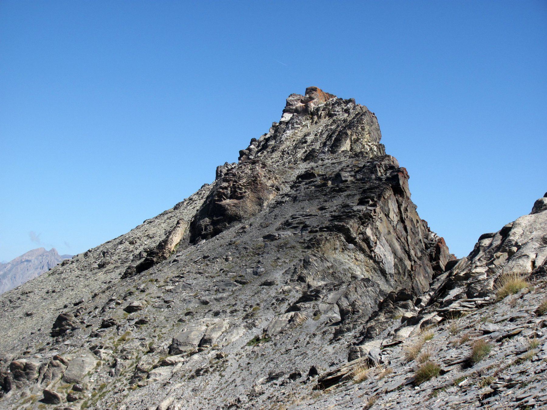 la cima, a sinistra dell'anticima con ometto, con roccia lichenata