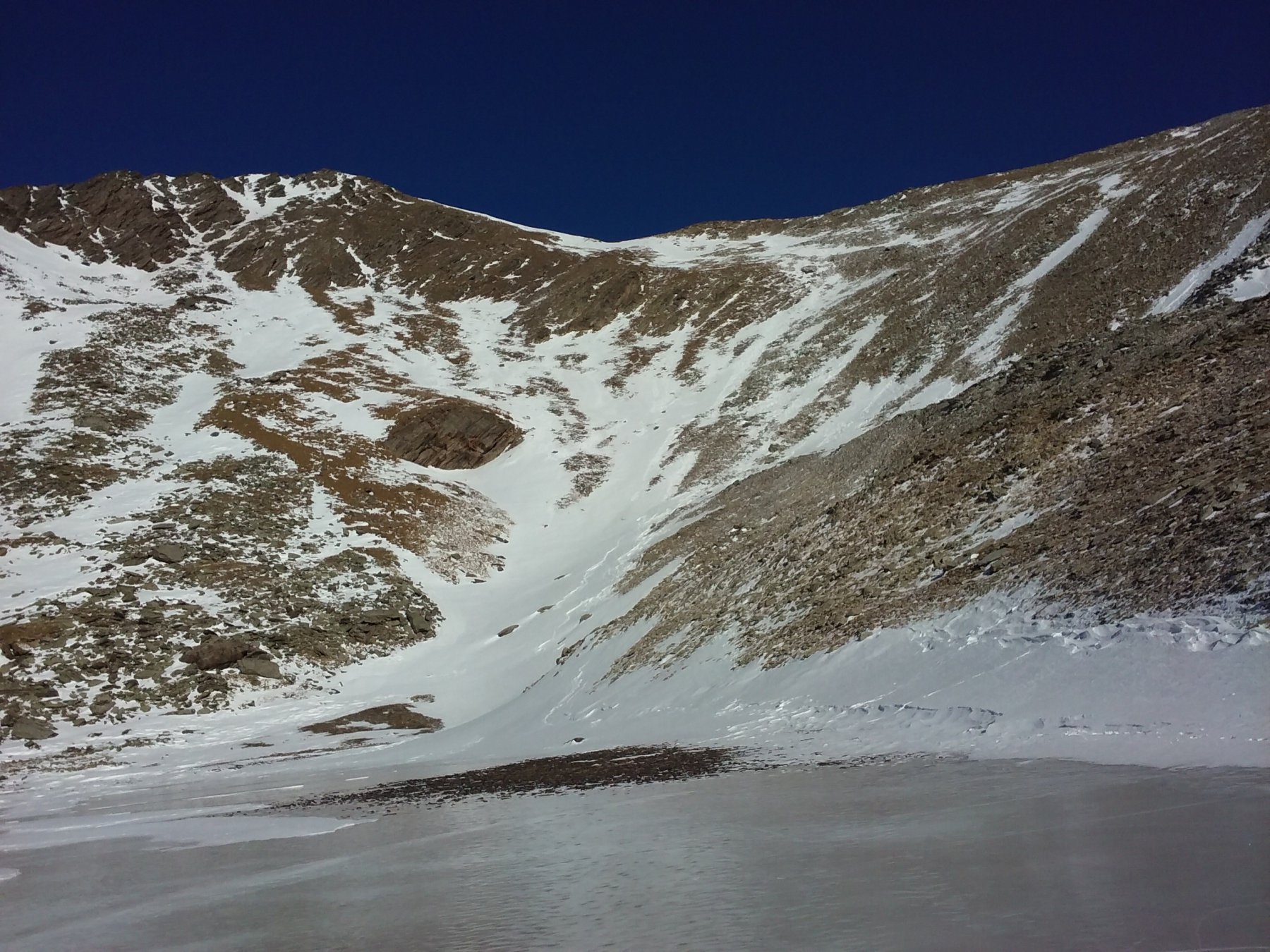 Lo scivolo nevoso sul fianco Sud della cima, visto dal lago Reisassa.