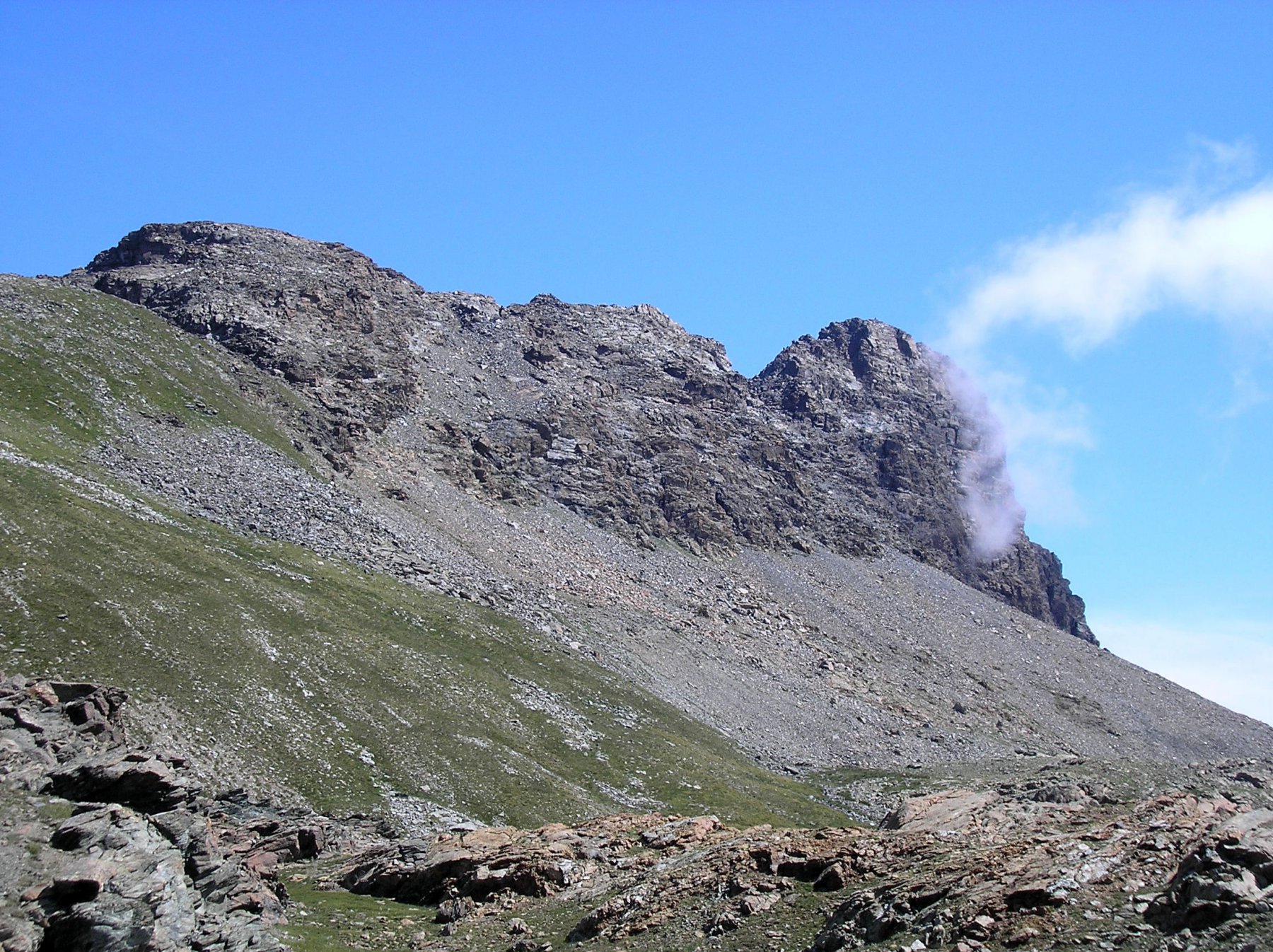 il pianoro che si taglia a mezza costa: visibile il conoide da raggiungere e il marcato intaglio che segna l'inizio della cresta