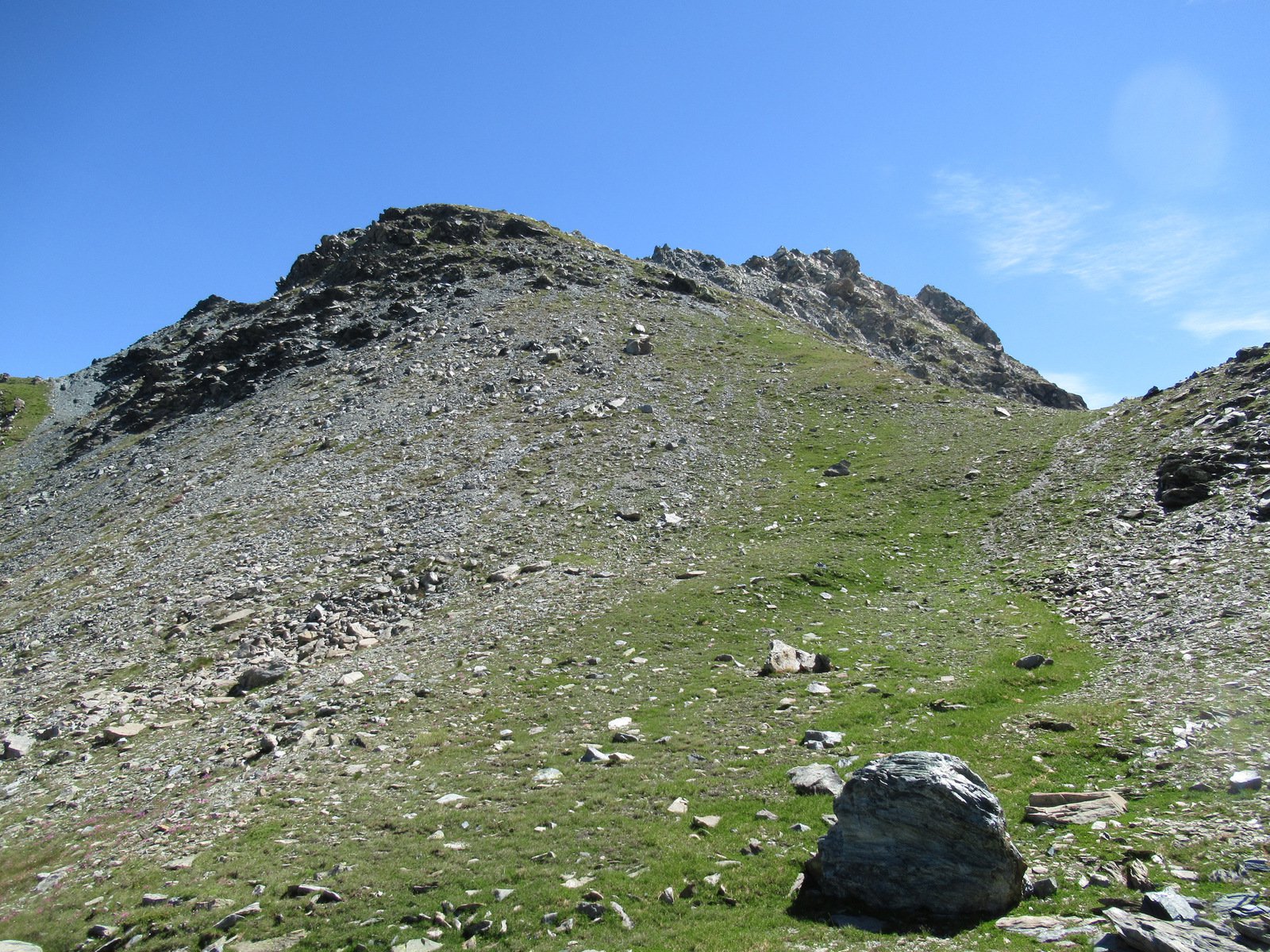 Il pendio erboso risalito e l'ampia depressione alla sua base visti arrivando dal Colle Larissa 
