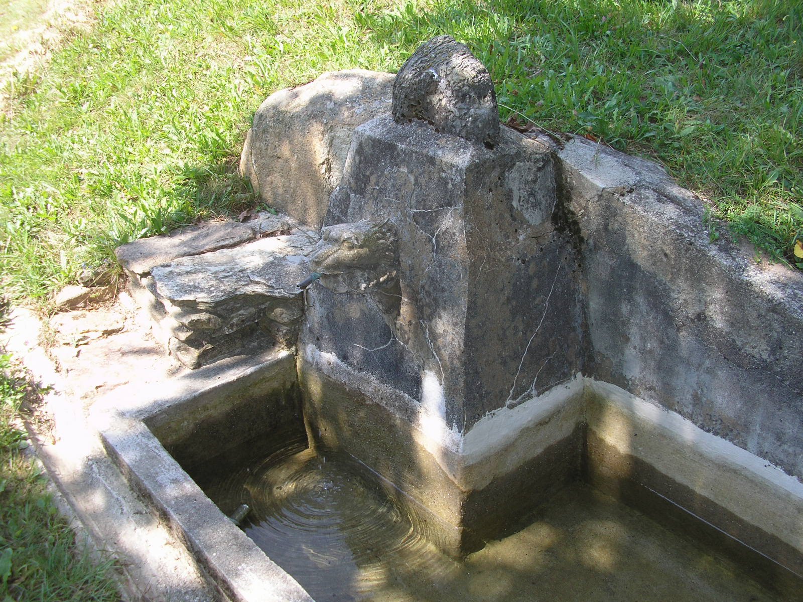 Fontana in pietra con protome leonina