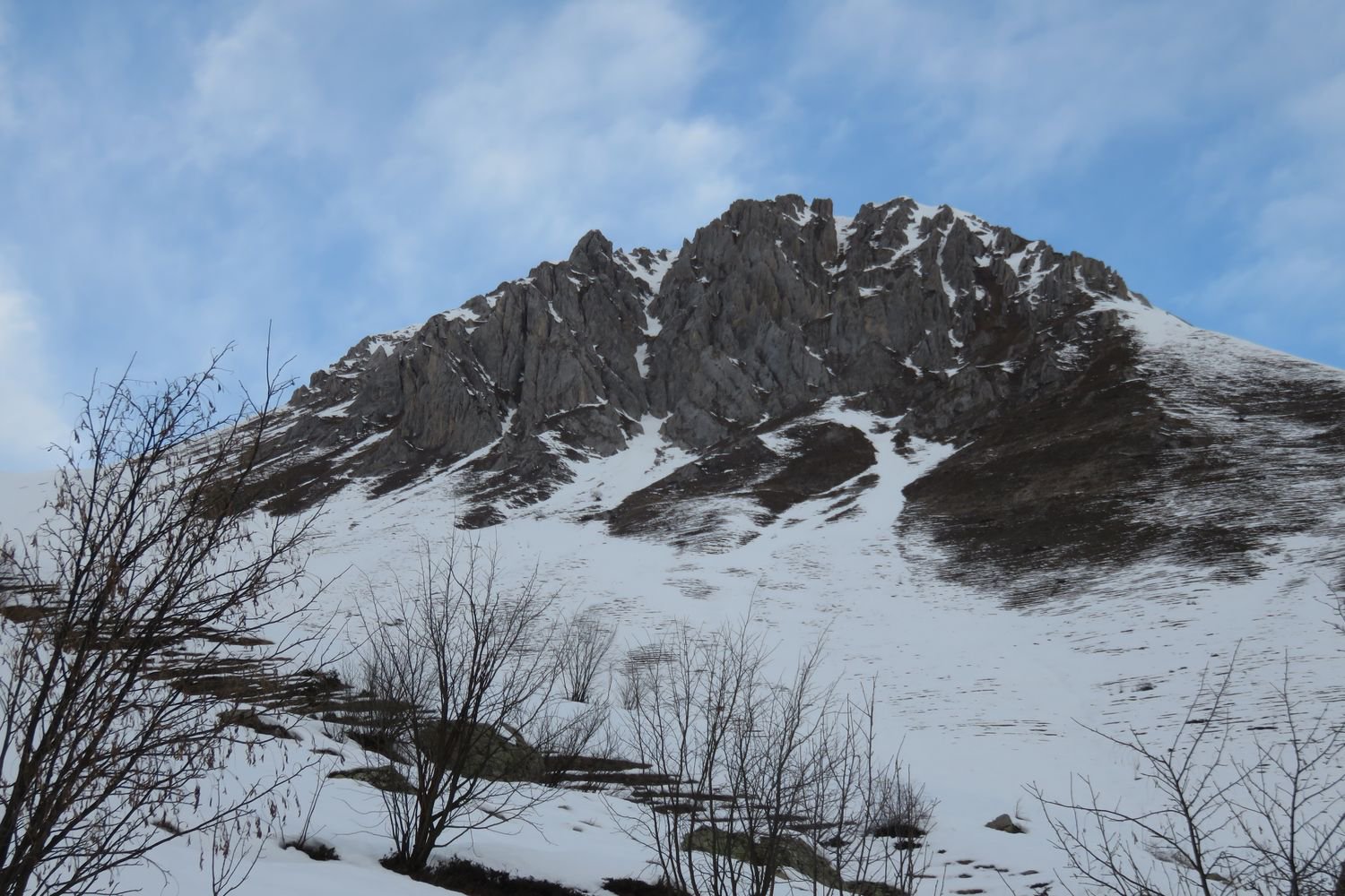 al centro della parete rocciosa, l'evidente canalino SE